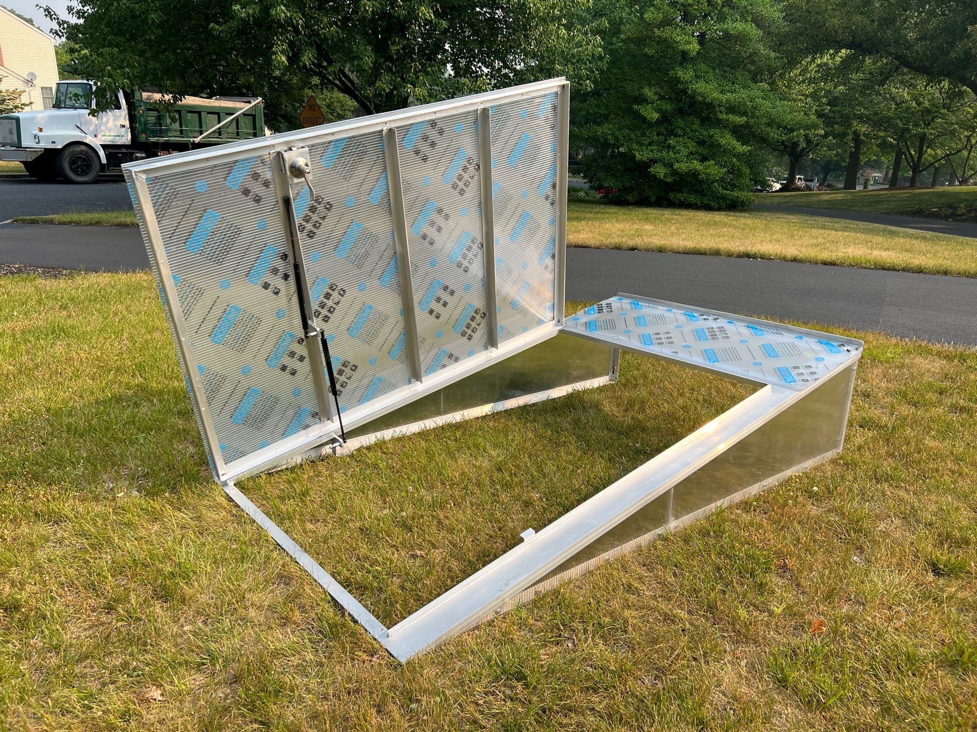 A metal box is sitting on top of a lush green field.