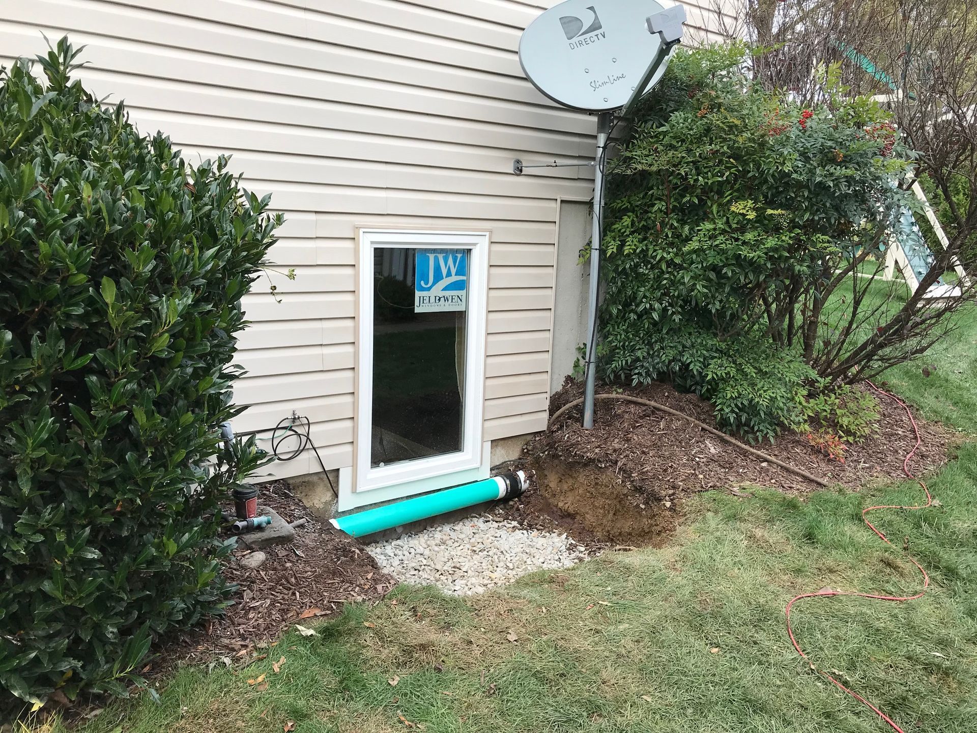 A shovel is leaning against a wall next to a pile of dirt.