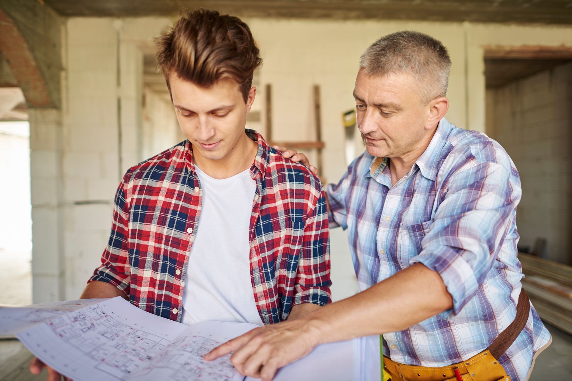 Two men are looking at a blueprint together.
