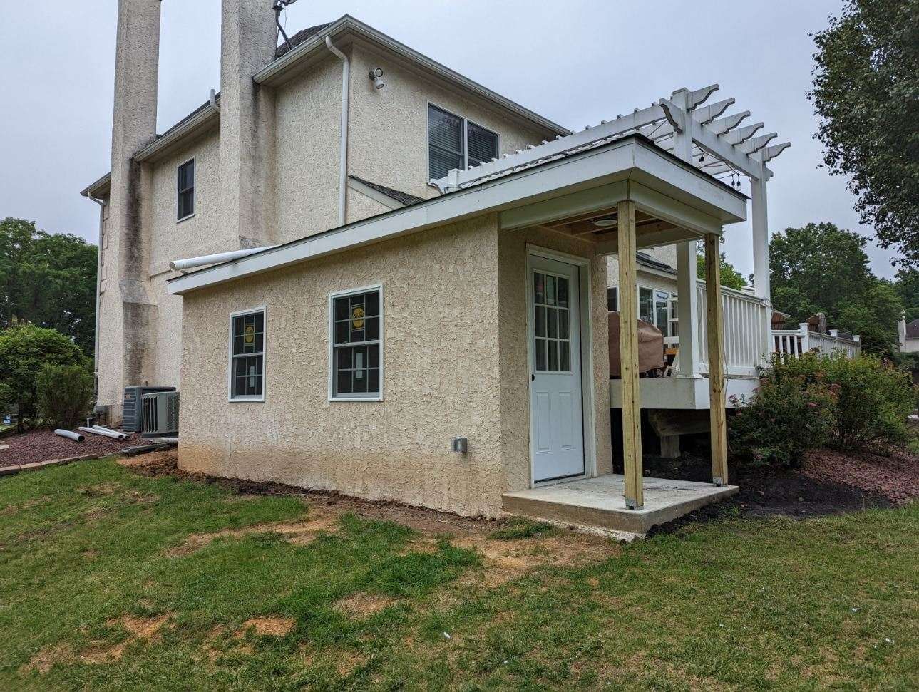 A house with a porch and a deck in the backyard.