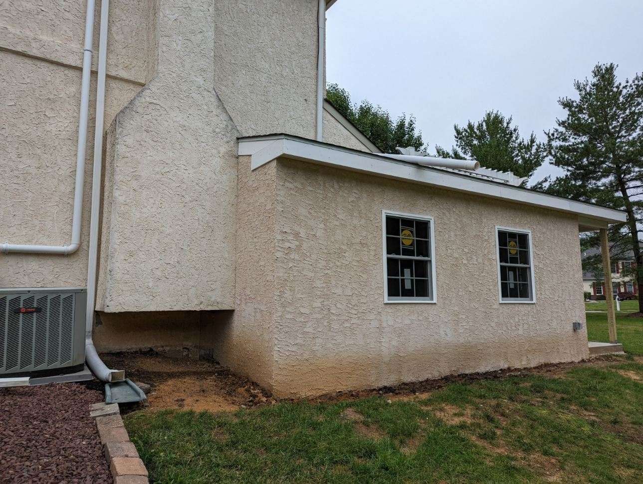 A house with a shed on the side of it and a lot of windows.