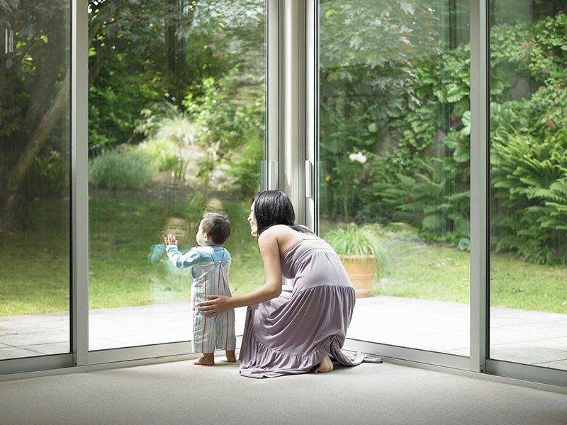 Mother and son looking out window - Glass Services in Saint Petersburg, FL Mother and son looking out window - Glass Services in Saint Petersburg, FL