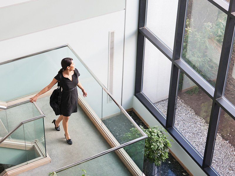 Businesswoman with briefcase on stairs on office building - - Glass Company in Saint Petersburg, FL Businesswoman with briefcase on stairs on office building - - Glass Company in Saint Petersburg, FL