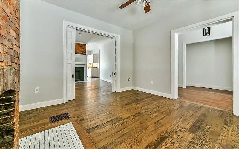 A living room with hardwood floors and a ceiling fan.