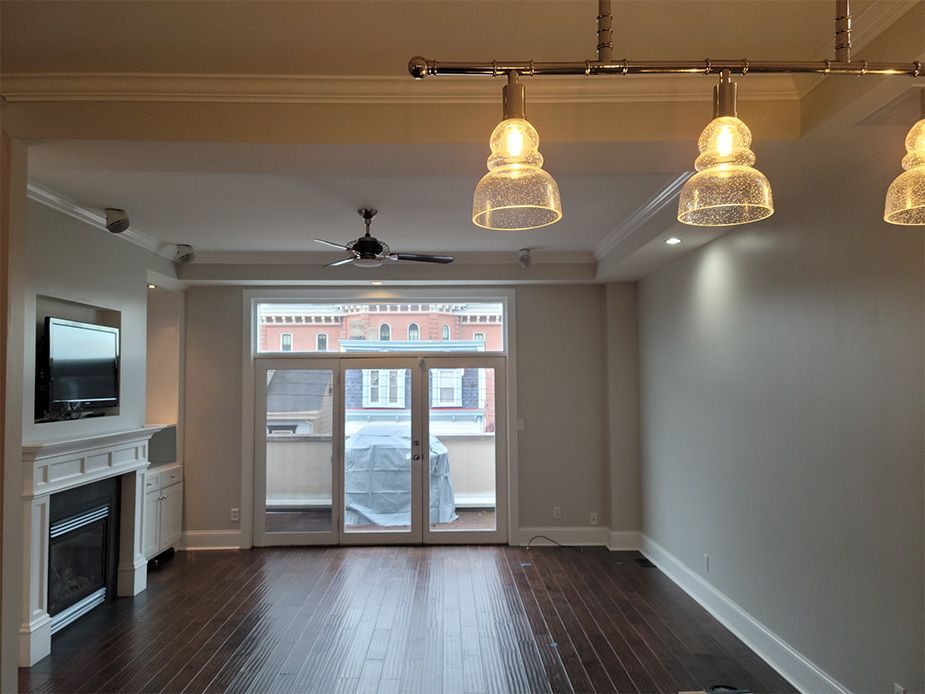 An empty living room with hardwood floors and a fireplace.