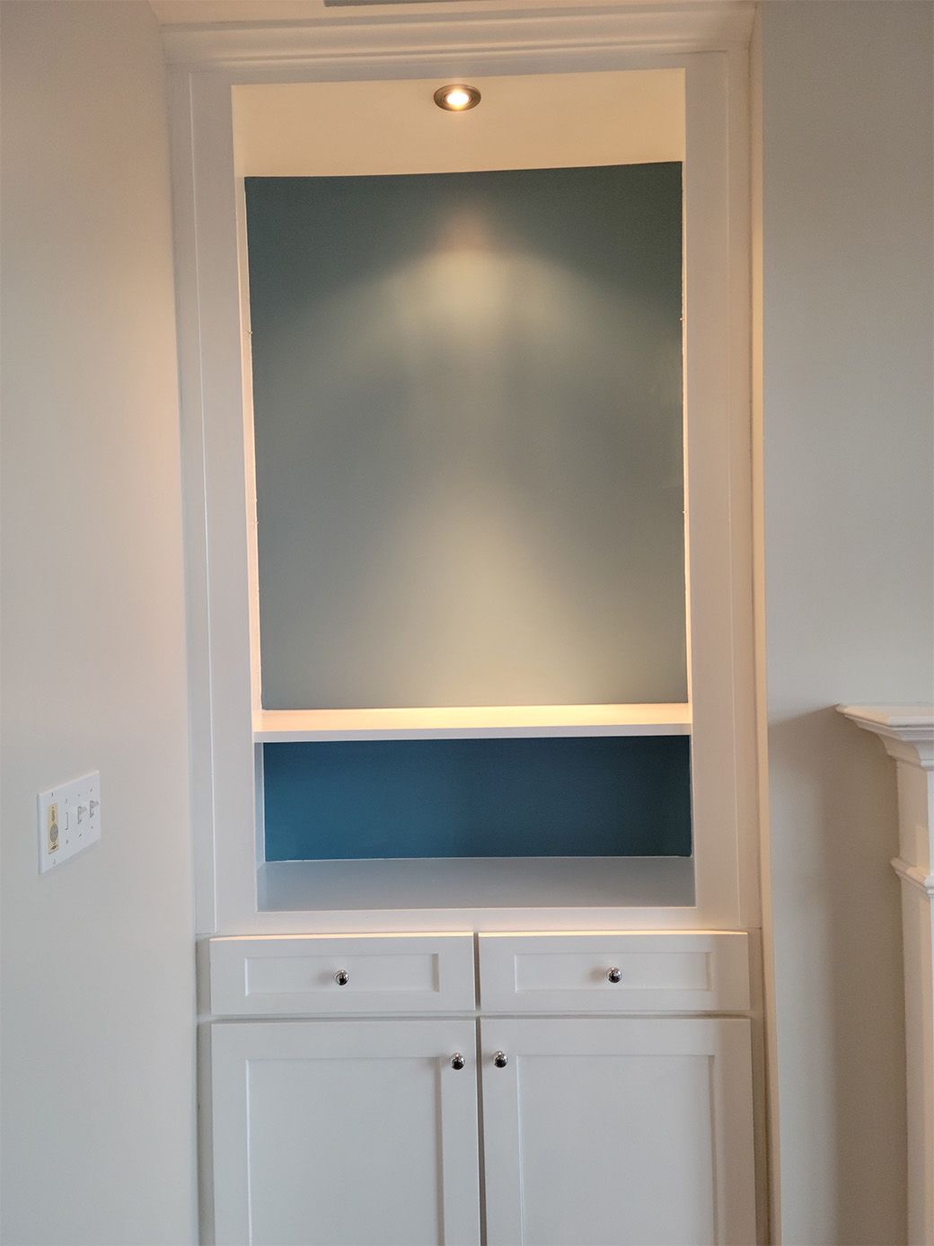 A white cabinet with a blue wall behind it