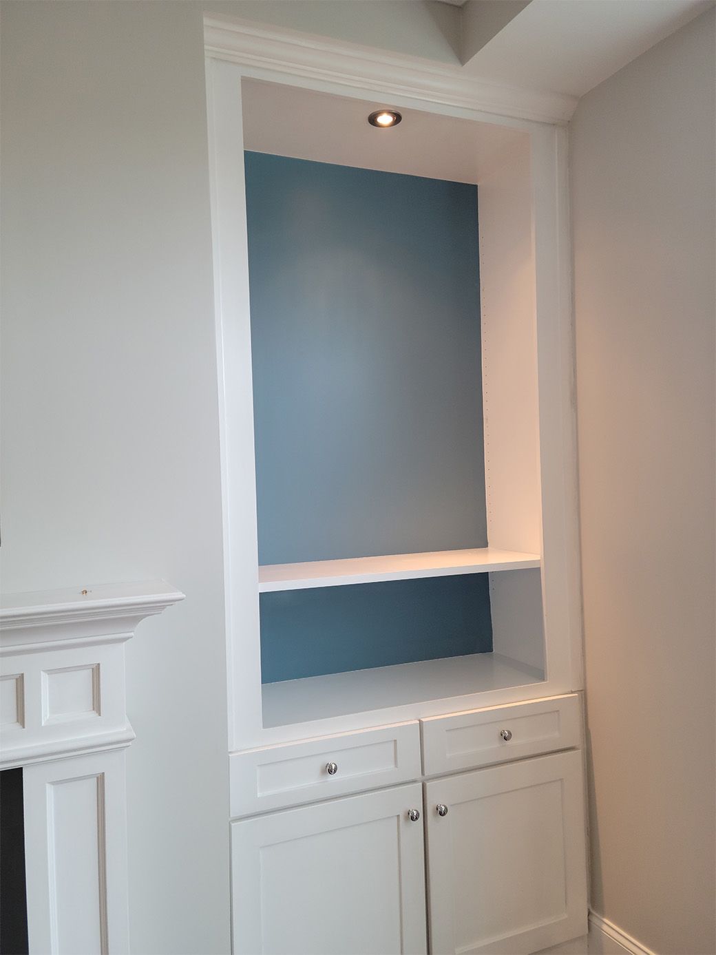 A white cabinet with a blue wall behind it