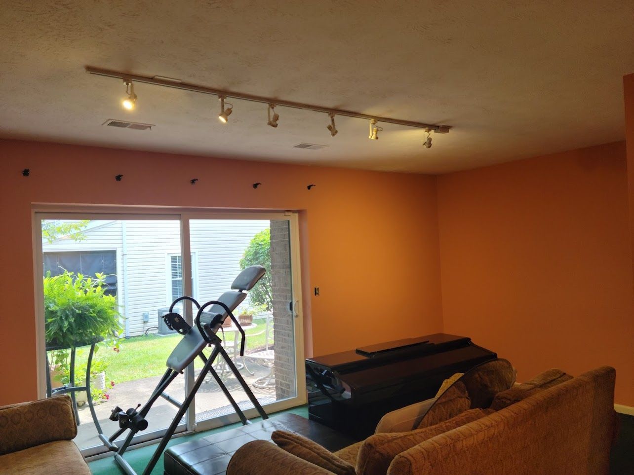 A living room with a couch and a treadmill in it