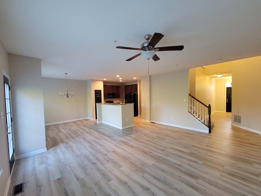 A living room with hardwood floors and a ceiling fan.