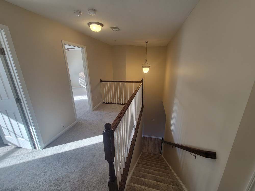 A hallway with stairs leading up to the second floor of a house.