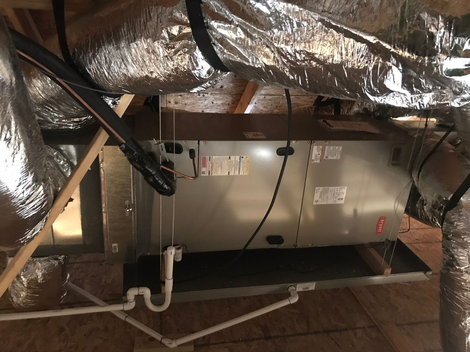 An air conditioner is sitting under a ceiling in a room.