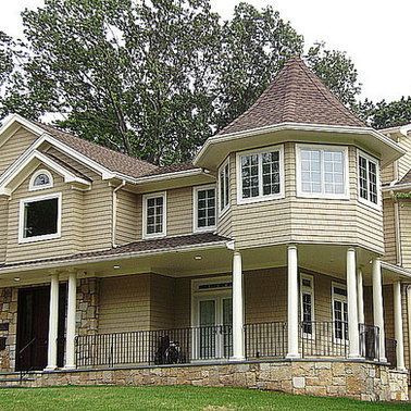 A large house with a large porch and a circular roof