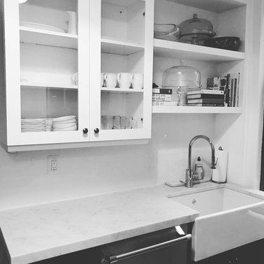A black and white photo of a kitchen with a sink and cabinets.