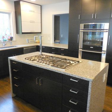 A kitchen with black cabinets and granite counter tops