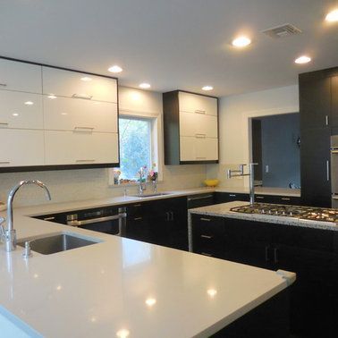 A kitchen with black cabinets and white counter tops