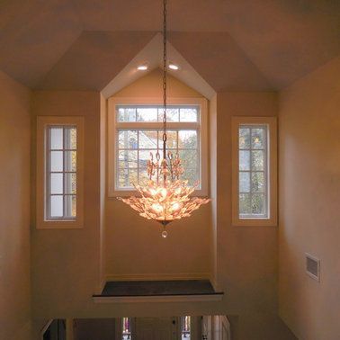 A chandelier is hanging from the ceiling in front of a window.