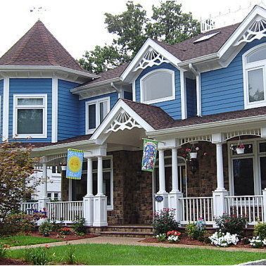 A blue house with white trim and a porch
