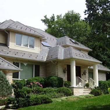 A large house with a gray roof and a large porch