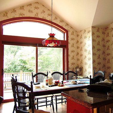 A dining room with a table and chairs and a large window