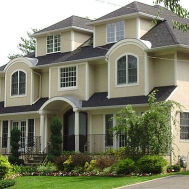 A large house with arched windows and a black roof