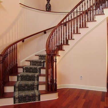 A curved staircase with a carpeted runner on the steps