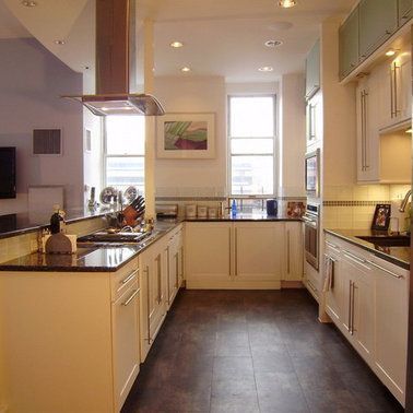 A kitchen with white cabinets and black counter tops
