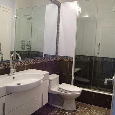 A bathroom with a toilet , sink and shower.