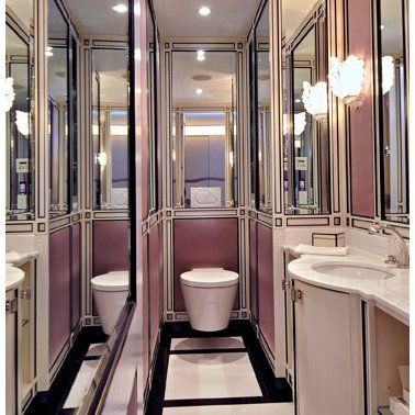 A bathroom with a toilet a sink and mirrors