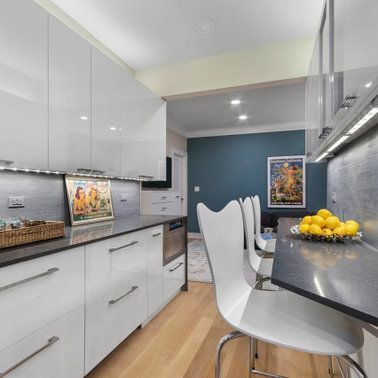A kitchen with a table and chairs and a bowl of lemons on the counter.