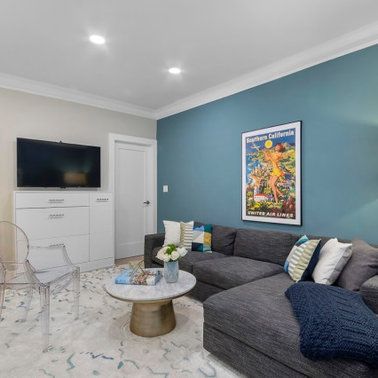 A living room with a couch , table , chair and television.