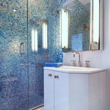 A bathroom with a sink , mirror and walk in shower.