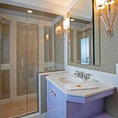 A bathroom with a sink , mirror and walk in shower.