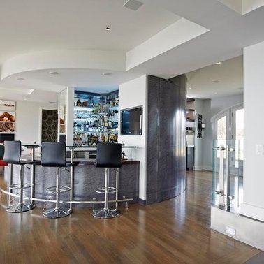 A room with a bar and stools in it