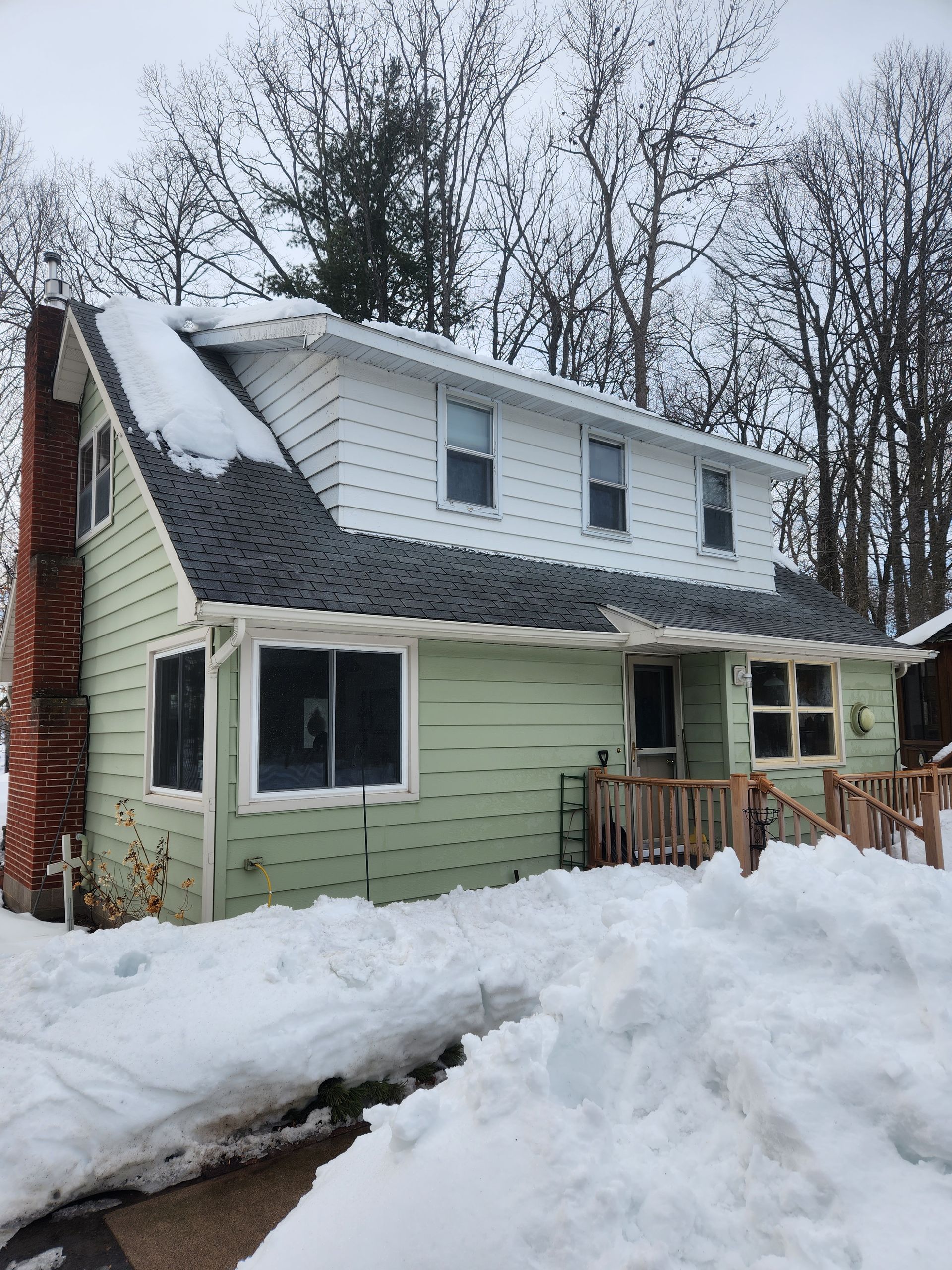 A house with a lot of snow on the ground in front of it