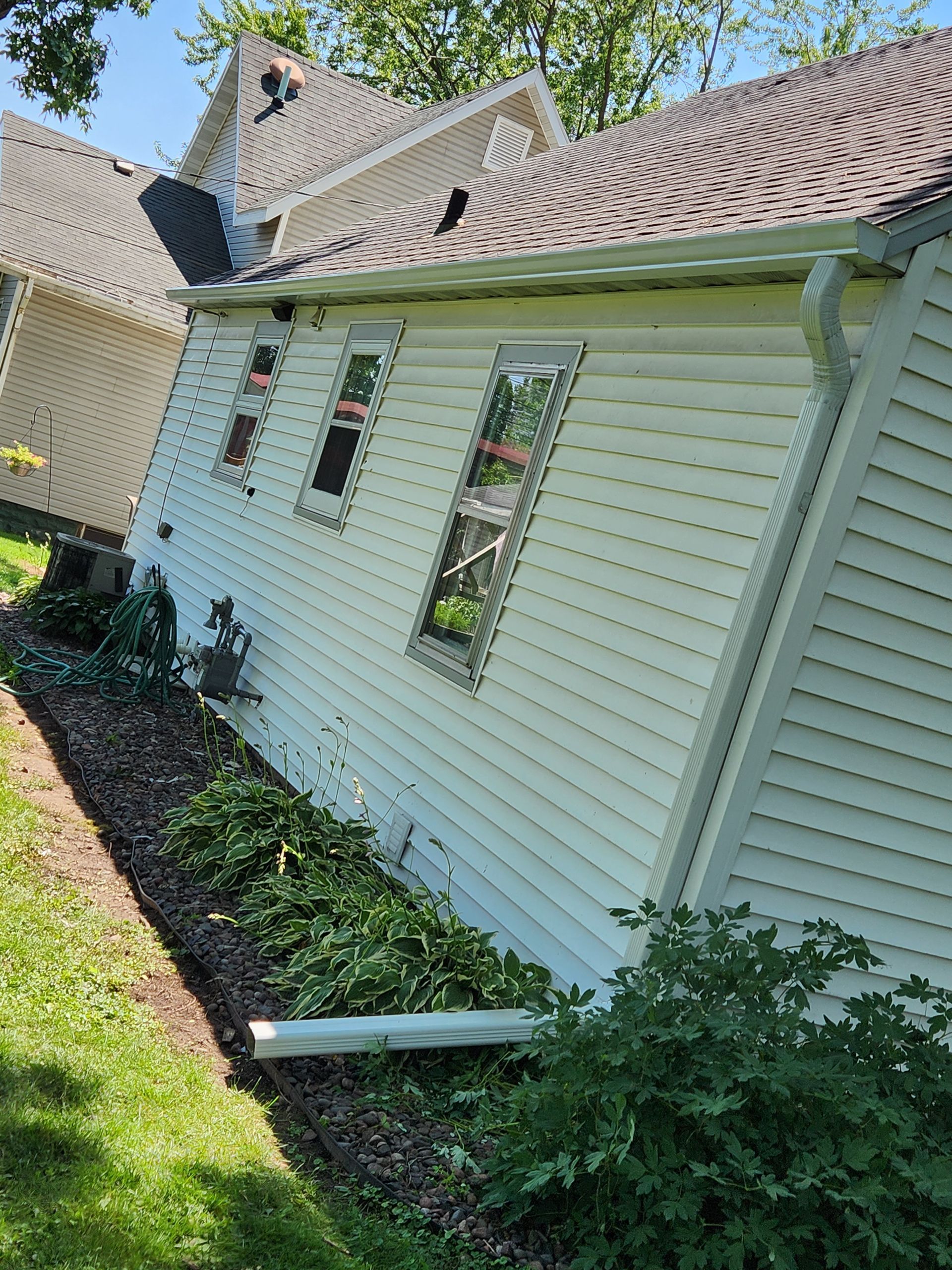 A white house with a roof that has fallen over.