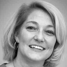 A woman is smiling in a black and white photo.