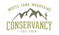 A logo for white tank mountains conservancy with a mountain and a cactus.
