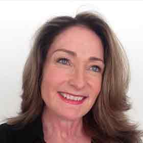 A woman with long brown hair is smiling for the camera.