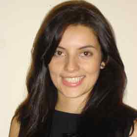 A woman with long dark hair is smiling for the camera.