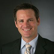 A man in a suit and tie is smiling for the camera.
