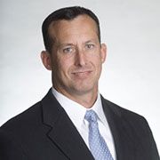 A man in a suit and tie is smiling for the camera.