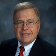 A man in a suit and tie is smiling for the camera.