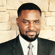 A man with a beard is wearing a suit and tie.