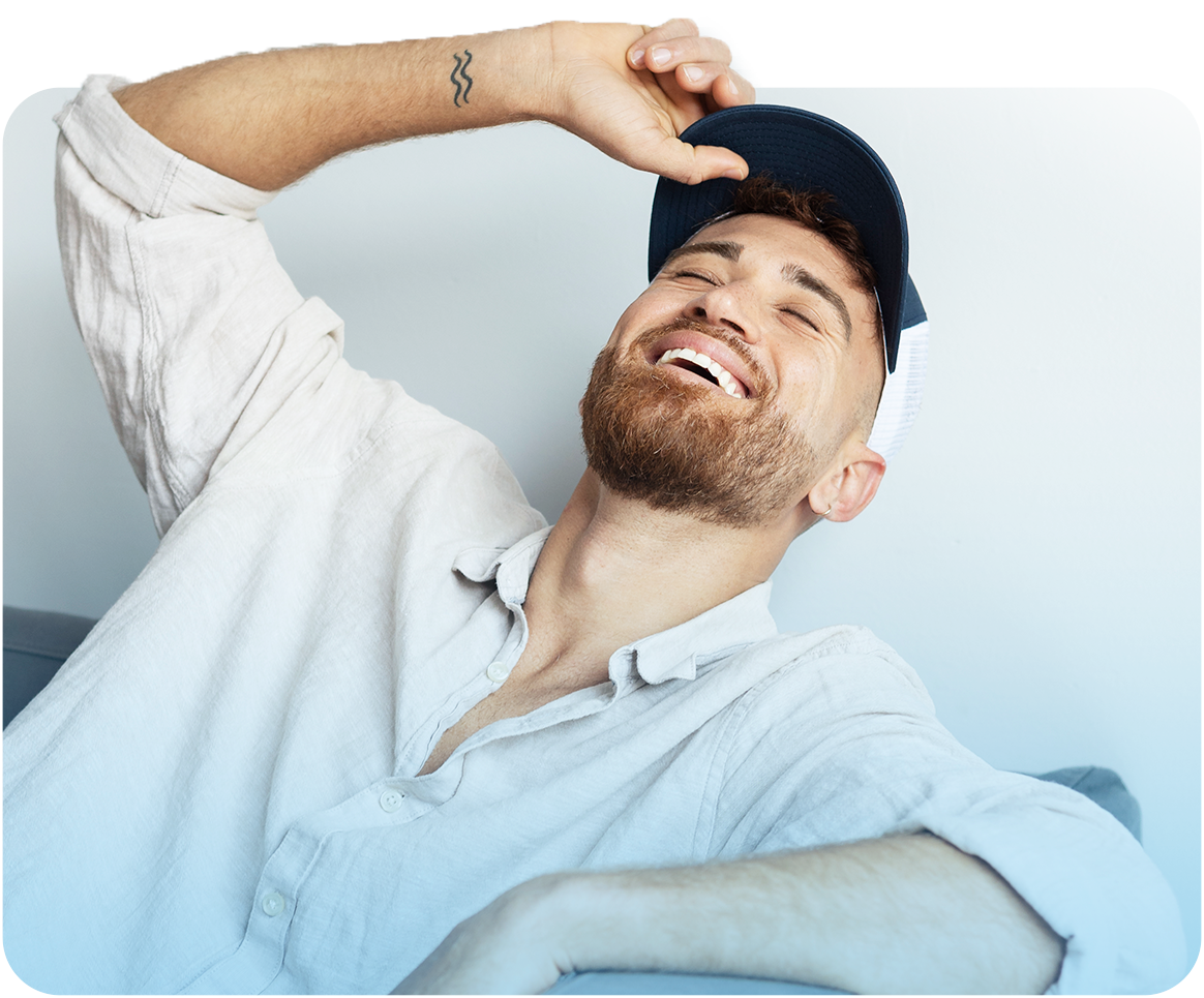 Man relaxing and smiling while sitting comfortably on a couch.