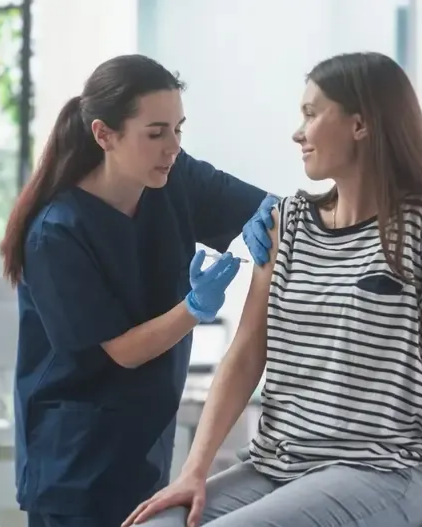 Nurse administering a vitamin injection to a patient in a medical office setting.