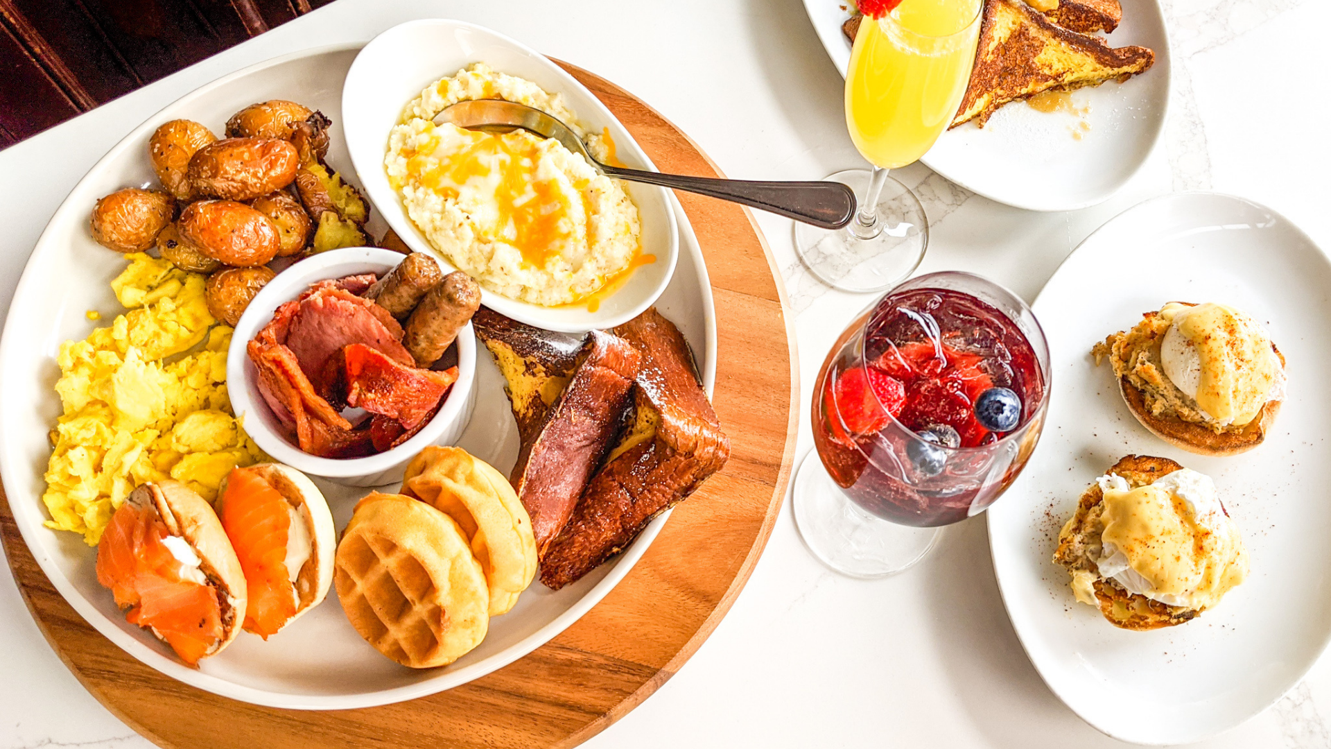 A table topped with plates of food and a glass of wine.