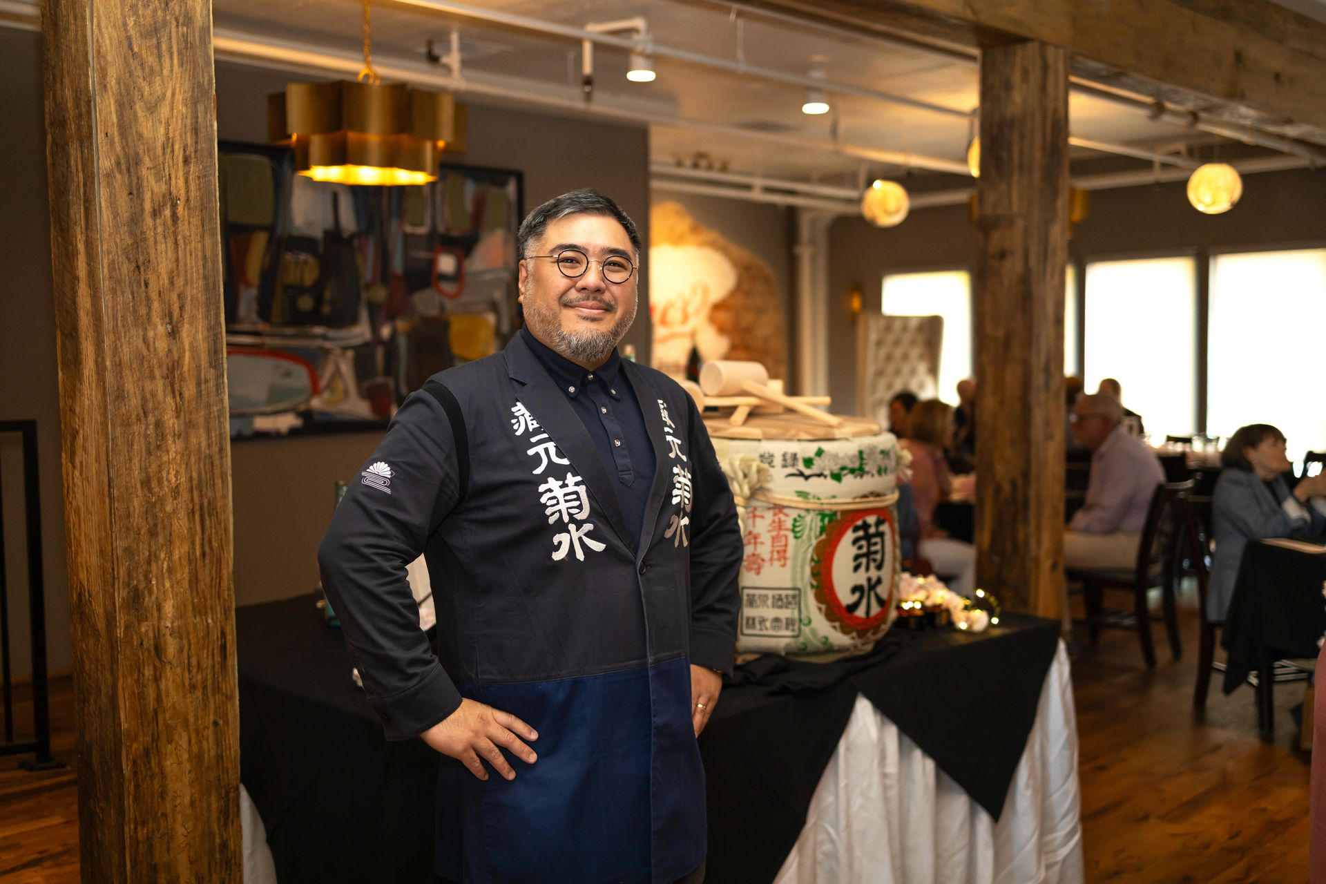 A man is standing in a restaurant with his hands on his hips.