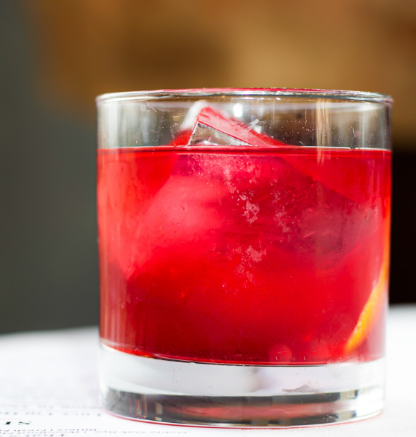 A close up of a glass of red liquid on a table.