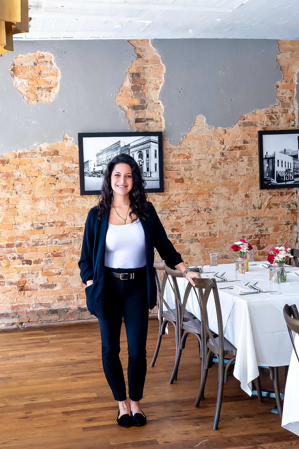 A woman is sitting at a table holding a plate of food.