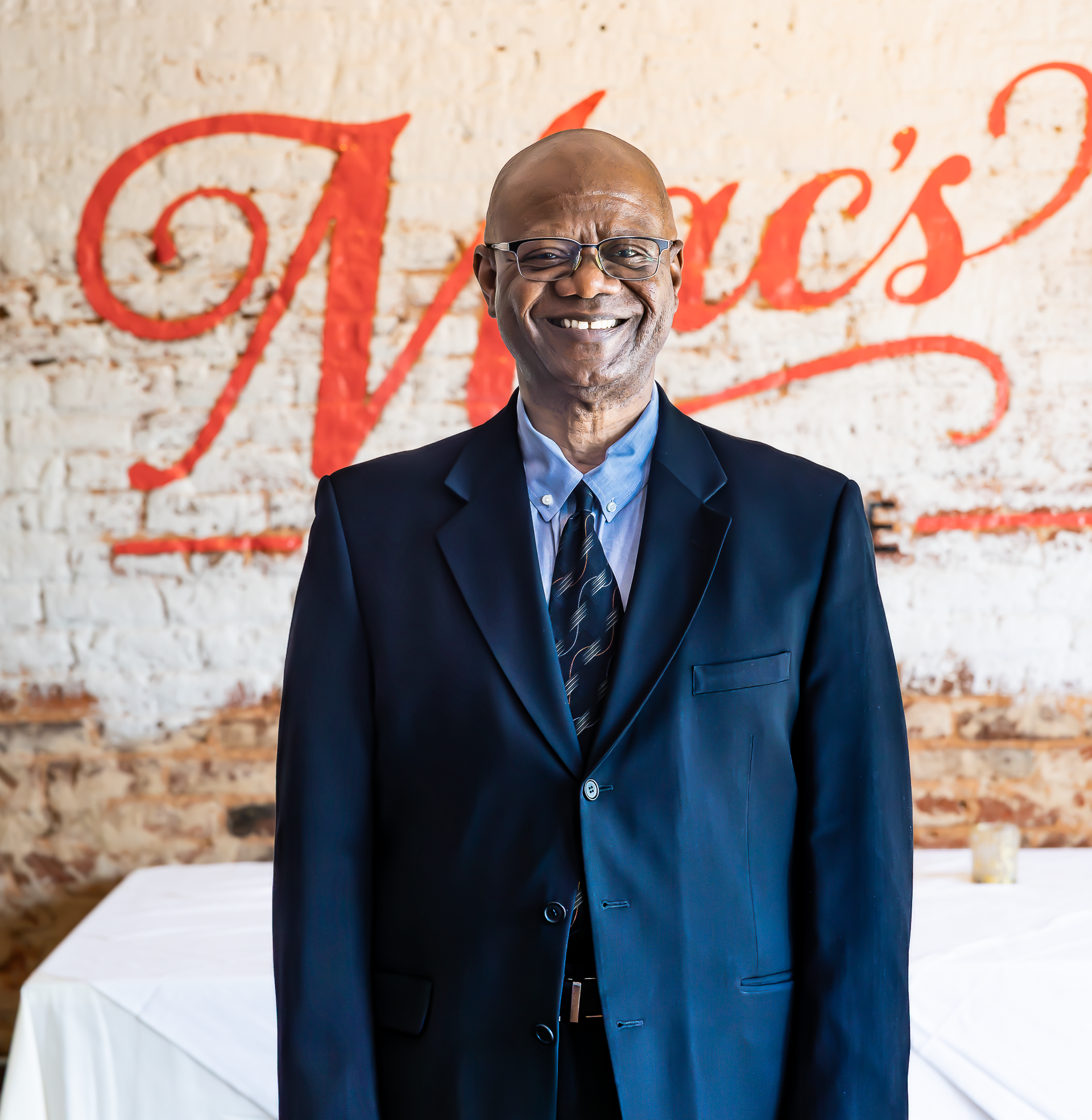 A woman is sitting at a table holding a plate of food.